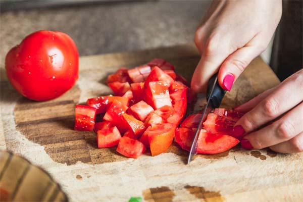 خرد کردن گوجه فرنگی در تهیه دمی گوجه با سیب زمینی
