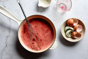 حرارت دادن به مخلوط تخم مرغ و آب پرتقال در تهیه تارت پرتقال خونی