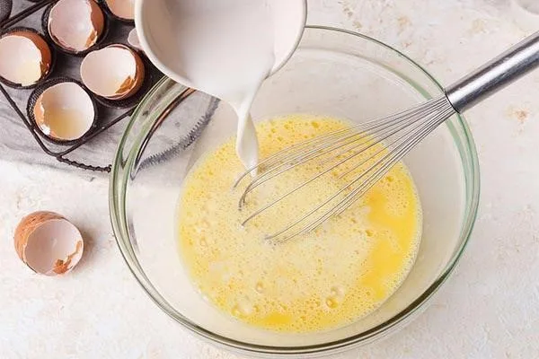 مخلوط تخم مرغ و شیر برای تهیه پیتزای اسکرامبلد