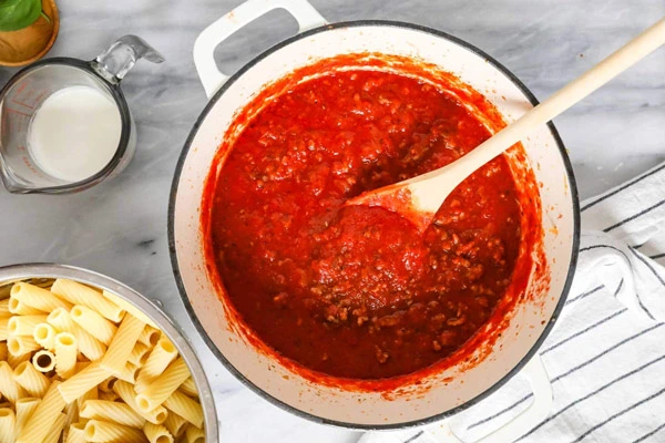 افزودن سوسیس و گوجه فرنگی پوره شده 