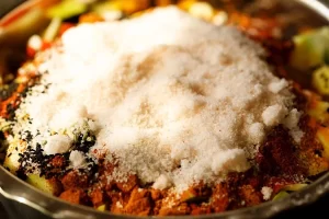 افزودن نمک به انبه های خرد شده در تهیه ترشی انبه پاکستانی