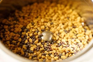 ریختن دانه‌های شنبلیله و خردل در آسیاب چج