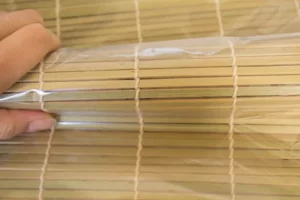 فشار دادن حصیر سوشی به رول سوشی