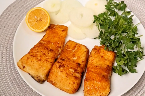 یک بشقاب ماهی سرخ شده ترد با دورچین جعفری و پیاز و لیمو
