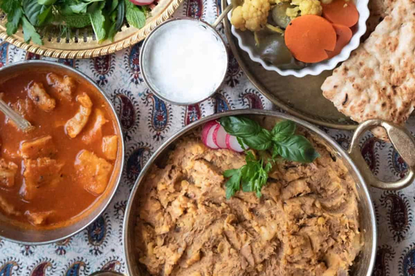 سرو آبگوشت زابلی در کنار ترشی و سبزی خوردن