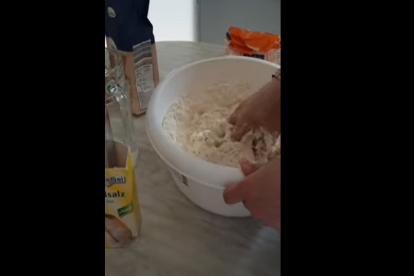 ریختن آرد گندم در یک کاسه بزرگ برای تهیه رشته آشی
