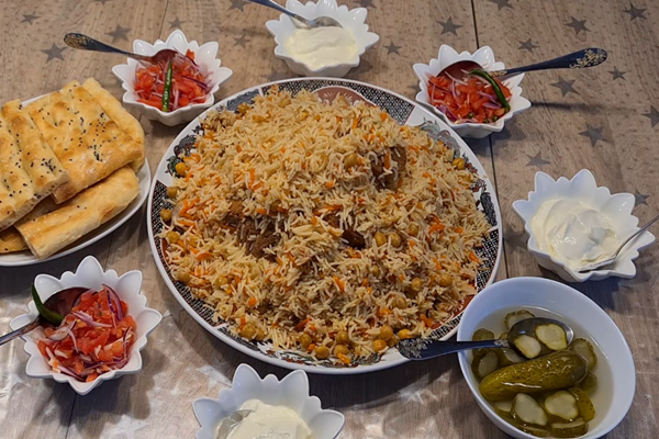 یک دیس پلو ازبکی با نخود خوشمزه در کنار ماست و خیارشور و ترشی