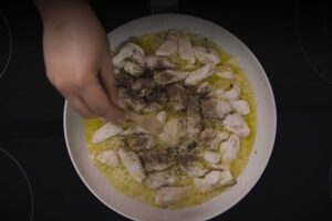 افزودن پوره سیر، نمک، فلفل به مرغ چیکن آلفردو