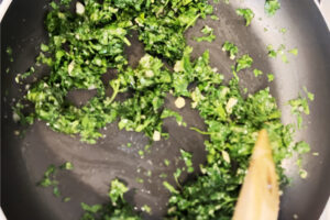 تفت دادن سیر و گشنیز برای افزودن به خورشت بامیه با رب انار