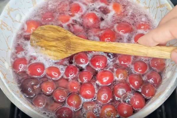 جوشاندن گیلاس‌ها در آب برای تهیه شربت گیلاس