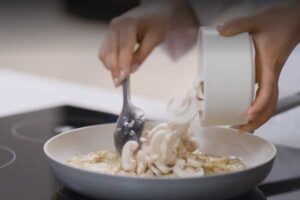 افزودن قارچ خردشده به داخل تابه