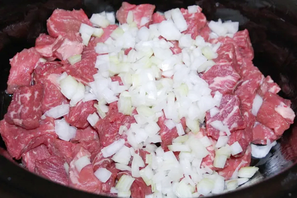 تفت دادن گوشت گوسفندی با پیاز و سیر در تهیه خورشت بامیه با گوشت گوسفندی