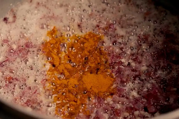 تفت دادن سیر و پیاز به همراه ادویه‌ها در تهیه آش ترخینه کرمانشاه