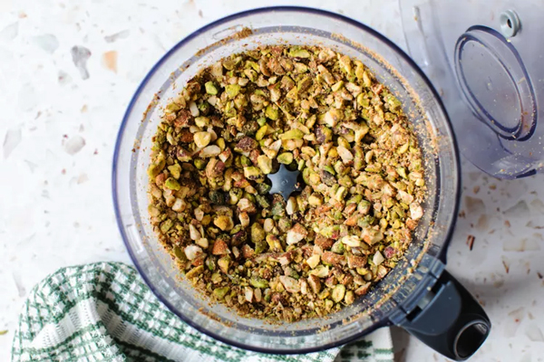 مخلوط کردن مغزیجات برای تهیه فیلینگ باقلوا در منزل