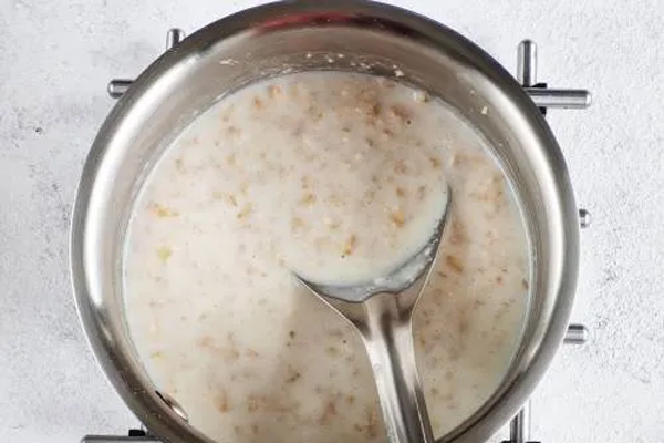 مخلوط کردن شیر و جو دوسر برای تهیه پنکیک رژیمی با جو دو سر