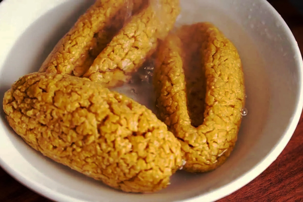 خیس کردن ترخینه‌ها در آب جوش برای تهیه آش ترخینه کرمانشاه