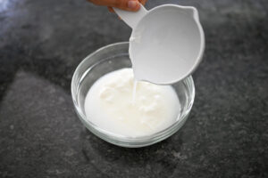 اضافه کردن آب به مخلوط ماست و سیر