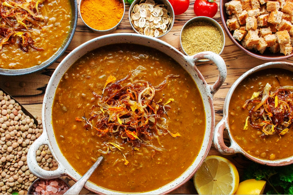 یک قابلمه عدسی رستورانی با تزئین پیازداغ