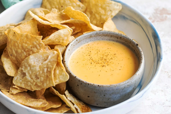 یک کاسه سس پنیر چدار در کنار نان پیتا