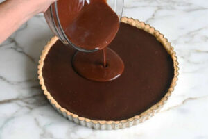 ریختن گلیز شکلاتی روی تارت