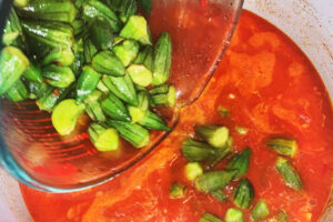 اضافه کردن بامیه ها به قابلمه در تهیه خورشت بامیه