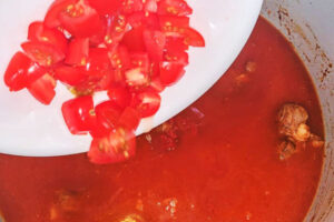 اضافه کردن گوجه فرنگی خرد شده به خورشت بامیه