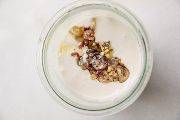 اضافه کردن مخلوط موسیر، سیر، پوست لیموترش له شده به ماست تازه پرچرب کاله