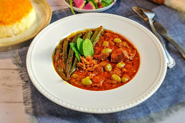 خورشت بادمجان با بامیه در ظرف گود با برنج زعفرانی