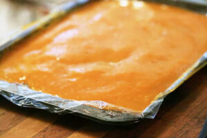 ریختن پوره سیب در سینی در تهیه لواشک سیب