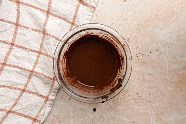 مخلوط کردن آب جوش، قهوه فوری و پودر کاکائو در تهیه کیک شکلاتی با پودر کاکائو