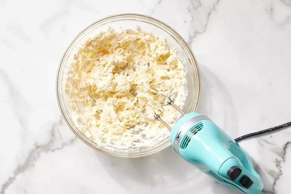 مخلوط کردن پنیر خامه‌ای،کره و وانیل در تهیه کرم پنیری