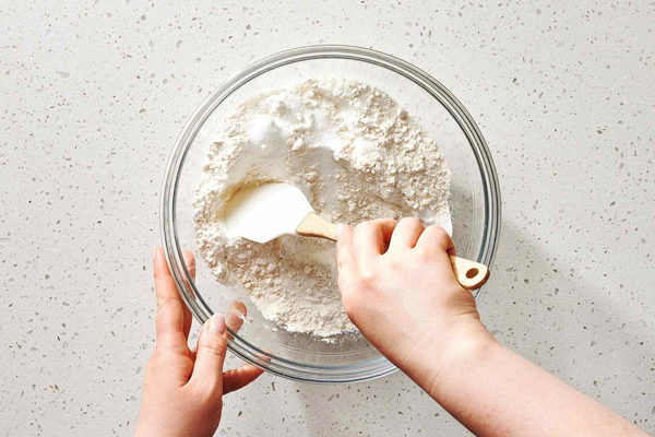 مخلوط کردن مواد خشک در تهیه کیک شکلاتی با پودر کاکائو