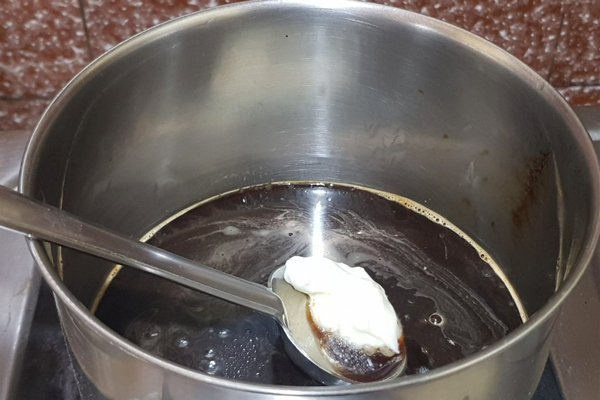 مخلوط کردن قهوه فوری، شکر، آب و جوشاندن آنها برای تهیه سس قهوه