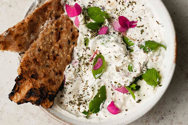 یک کاسه ماست موسیر با تزئین نعنا و نان محلی