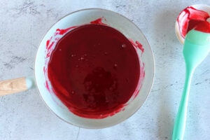 افزودن رنگ خوراکی قرمز به شربت برای تهیه آبنبات عصایی