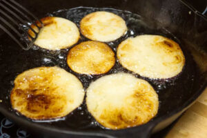 سرخ کردن بادمجان در تابه برای تهیه ته چین مرغ و بادمجان