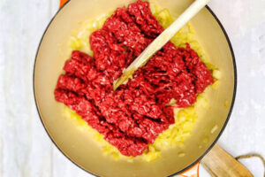 اضافه کردن گوشت چرخکرده برای سس گوشت به تابه