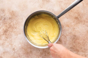 ترکیب مواد کرم تارت نوتلا با همزن دستی در شیرجوش