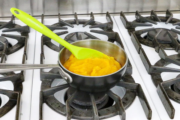 پوره کدو حلوایی در قابلمه روی اجاق گاز برای تهیه لواشک