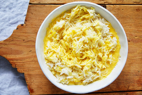 مخلوط کردن برنج با مایه ته چین برای تهیه ته چین مرغ و بادمجان