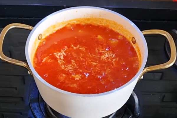 اضافه کردن برنج برای تهیه دمپختک گوجه بدون گوشت