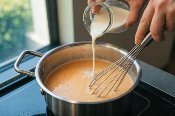 اضافه کردن شیر و ایجاد بافت سس برای تهیه پنیر چدرا مایع