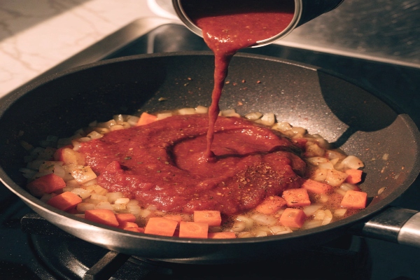  افزودن رب گوجه‌فرنگی برای تهیه سوپ مرغ و جو