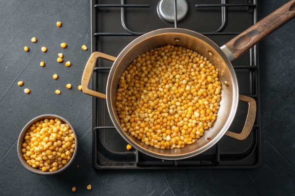 ذرت در قابلمه برای تهیه پفیلا گوجه ای