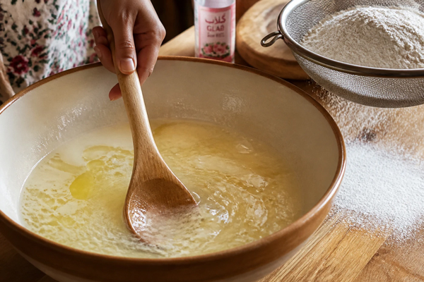 مخلوط کردن آب، روغن، گلاب و افزودن آرد