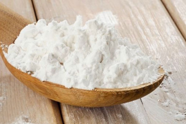 یک پیمانه نشاسته ذرت در قاشق چوبی
