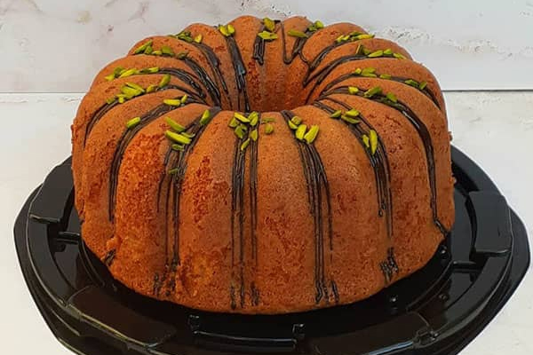 کیک ساده خانگی با تزئین خلال پسته و سس شکلات