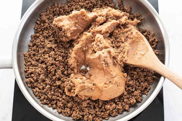 آماده‌سازی مایه گوشت در طرز تهیه ناچو با خامه ترش