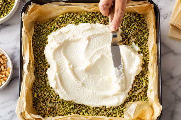 افزودن مغزیجات و تهشیر روی لایه‌های یوفکا در طرز تهیه باقلوا با تهشیر