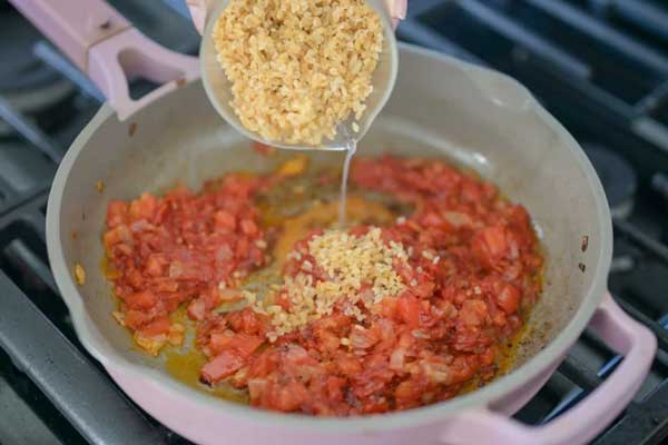 افزودن بلغور خیس‌خورده به مخلوط سس بلغور پلو